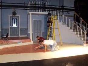 Students work on the set of "Rumors" - painting, and hanging lighting instruments.
